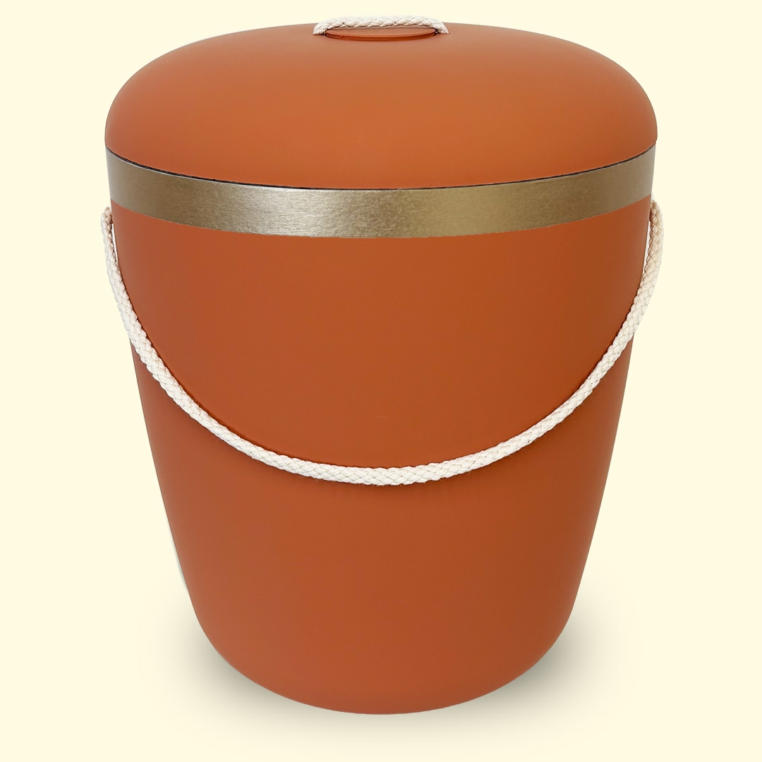 Oranssi uurna kultaisella koristeella sivustolta www.benutree.fi